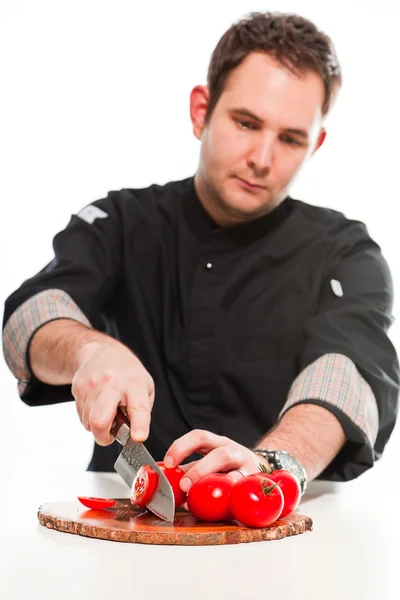 Jovem cozinheiro masculino com jaqueta preta preparando ingredientes crus . — Fotografia de Stock