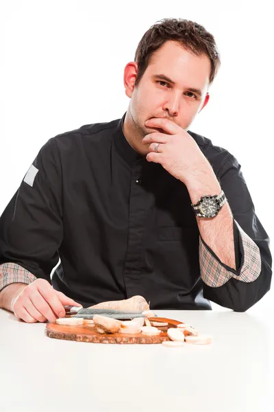 Jeune cuisinier masculin avec veste noire préparant des ingrédients bruts . — Photo