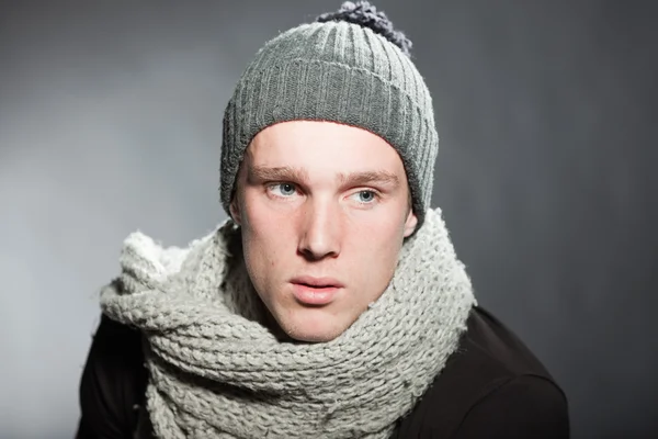 Modeatelier Porträt eines hübschen jungen Mannes vor grauem Hintergrund. — Stockfoto