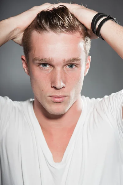 Fashion studio portrait of handsome young man against grey background. — Stock Photo, Image