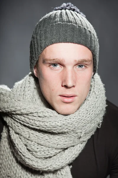 Fashion studio portrait of handsome young man against grey background.