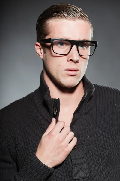 Modeatelier Porträt eines hübschen jungen Mannes vor grauem Hintergrund. — Stockfoto