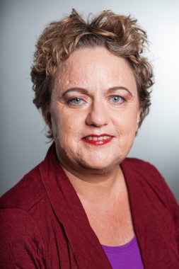 kısa kıvırcık saçlı kadın kıdemli. gri arka planı vurdu studio.