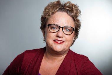 kısa kıvırcık saçlı kadın kıdemli. gri arka planı vurdu studio.