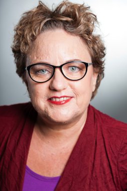 kısa kıvırcık saçlı kadın kıdemli. gri arka planı vurdu studio.