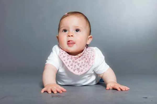 Nettes kleines Mädchen vor grauem Hintergrund. — Stockfoto