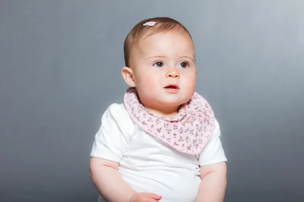 Bébé fille mignonne sur fond gris . — Photo