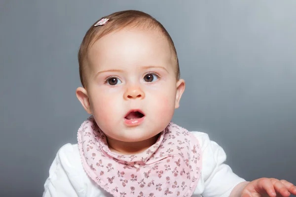 Bébé fille mignonne sur fond gris . — Photo