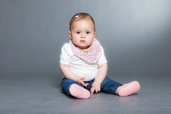 Bébé fille mignonne sur fond gris . — Photo