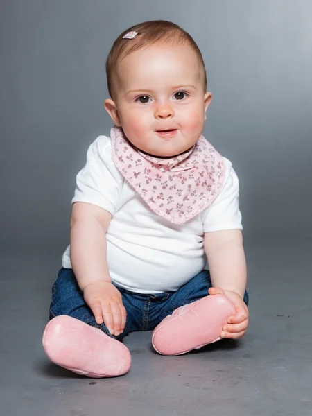 Cute baby girl against grey background. — Stock Photo, Image