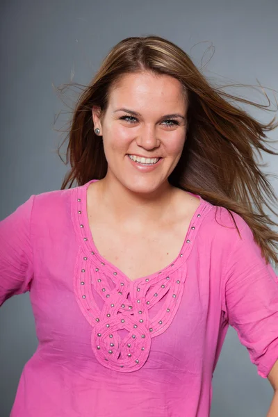 Pretty brunette woman with long hair against grey. — Stock Photo, Image