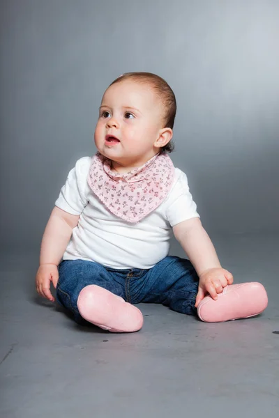 Bébé fille mignonne sur fond gris . — Photo