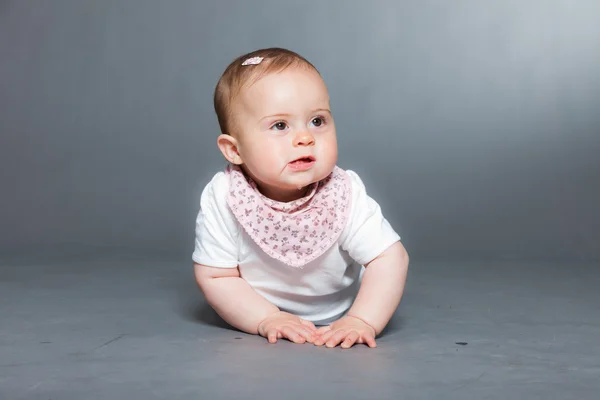 Cute baby girl against grey background. — Stock Photo, Image