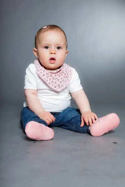 Nettes kleines Mädchen vor grauem Hintergrund. — Stockfoto