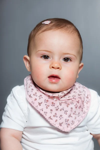 Bébé fille mignonne sur fond gris . — Photo