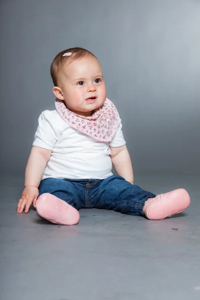 Nettes kleines Mädchen vor grauem Hintergrund. — Stockfoto