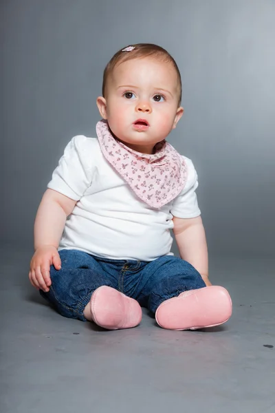 Bébé fille mignonne sur fond gris . — Photo