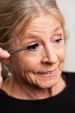 Makyaj yaparken kadın kıdemli.