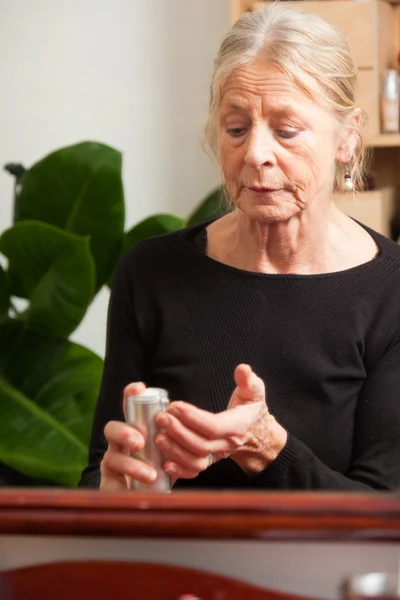 Mulher sênior fazendo maquiagem . — Fotografia de Stock