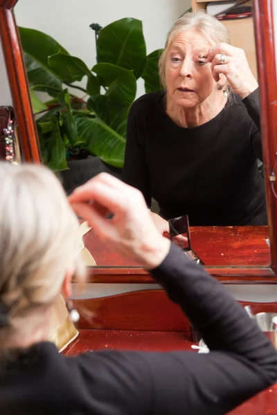 年配の女性のメーキャップäldre kvinna göra make-up. — Stock fotografie