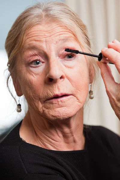 Senior woman doing make-up. — Stock Photo, Image