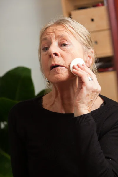 Seniorin schminkt sich. — Stockfoto