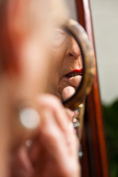 Senior woman doing make-up. — Stock Photo, Image