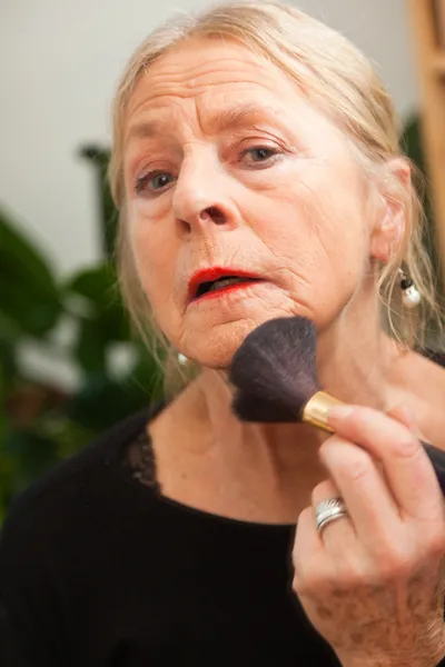 Mujer mayor haciendo maquillaje . — Foto de Stock