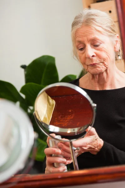 Senior woman doing make-up. — Stock Photo, Image