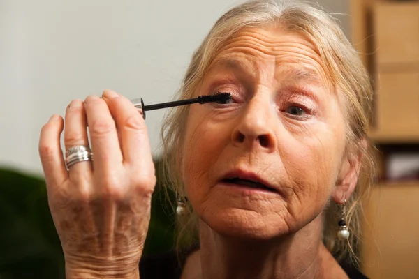 Senior woman doing make-up. — Stock Photo, Image