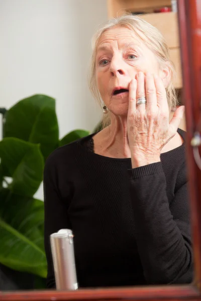 Senior woman doing make-up. — Stock Photo, Image