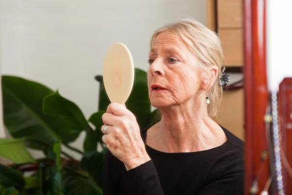 Mujer mayor haciendo maquillaje . — Foto de Stock