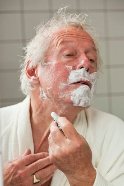 Senior man shaving his beard. — Stock Photo, Image