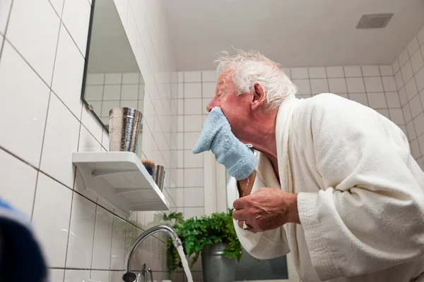 Senior wäscht sich sein Gesicht. — Stockfoto