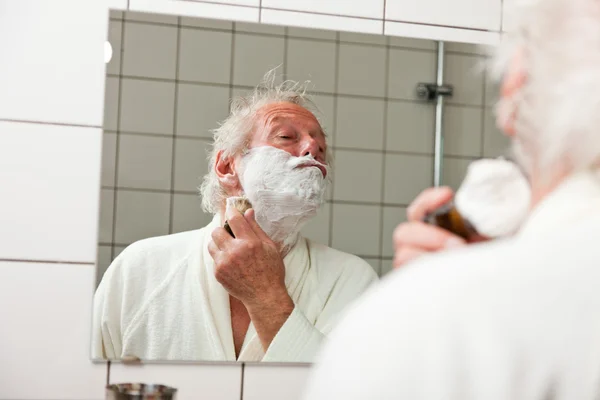 Homem sênior barbeando sua barba . — Fotografia de Stock