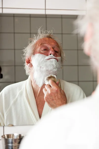 Senior man shaving his beard. — Stock Photo, Image