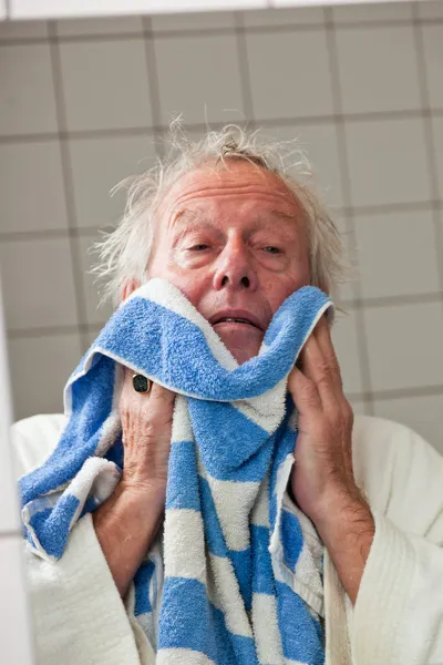 Senior man drying his face with towel. — Stock Photo, Image