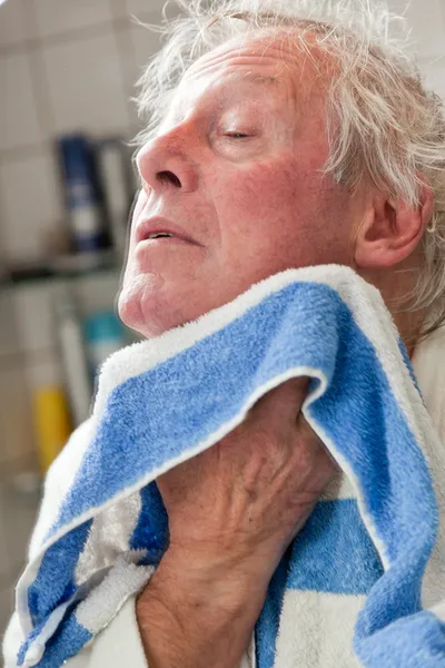 Senior man drying his face with towel. — Stock Photo, Image