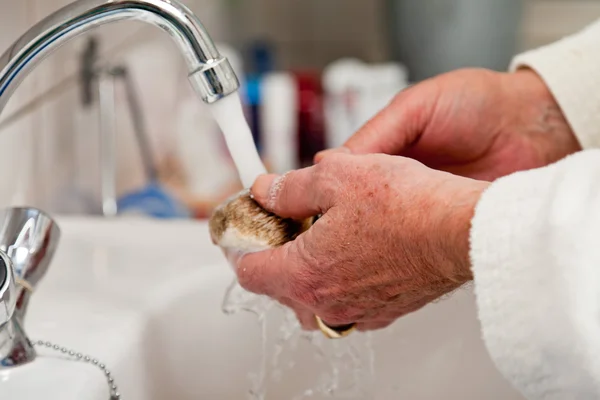 Closeup of hand cleaning shaving brush. — Stock Photo, Image