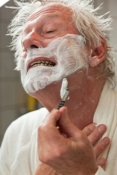 Senior man shaving his beard. — Stock Photo, Image