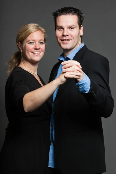 Young couple. Studio shot against grey. — Stock Photo, Image