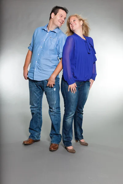 Young couple. Studio shot against grey. — Stock Photo, Image