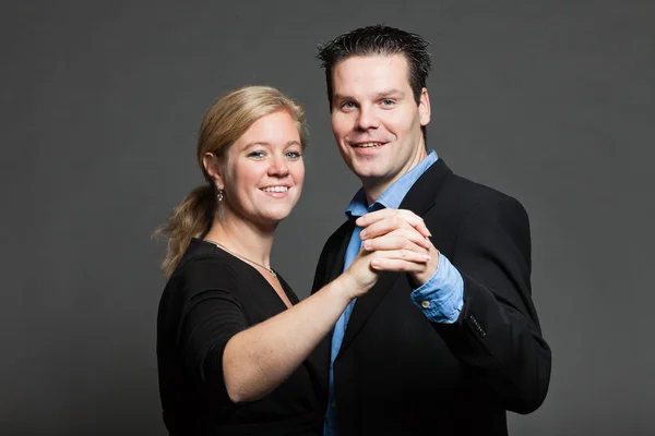 Young couple. Studio shot against grey. — Stock Photo, Image