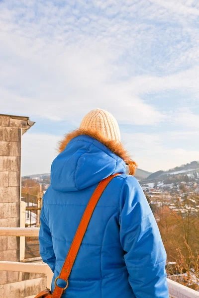 Frau von hinten blickt über Dorf im Schneetal. — Stockfoto