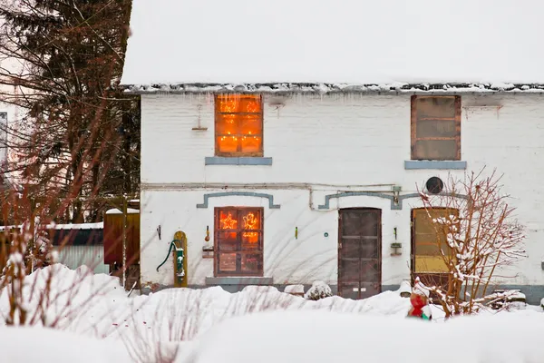 Maison avec neige. Lumières de Noël dans la fenêtre . — Photo