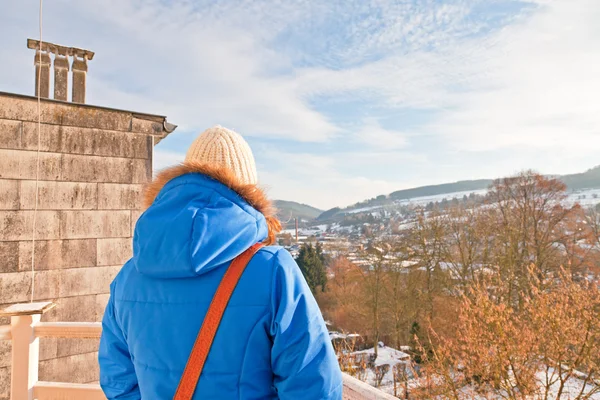 Mujer de atrás mirando por encima del pueblo en el valle de nieve . —  Fotos de Stock