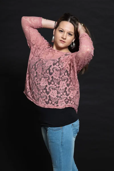 Pretty brunette girl against dark background. — Stock Photo, Image