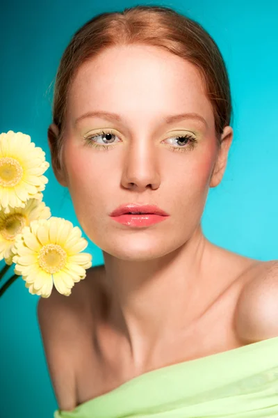 Krása portrét ženy s květinami a zrzavé vlasy. — Stock fotografie