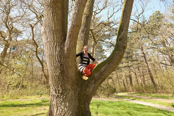 Single glücklich junge Frau hat Spaß im Baum. — Stockfoto