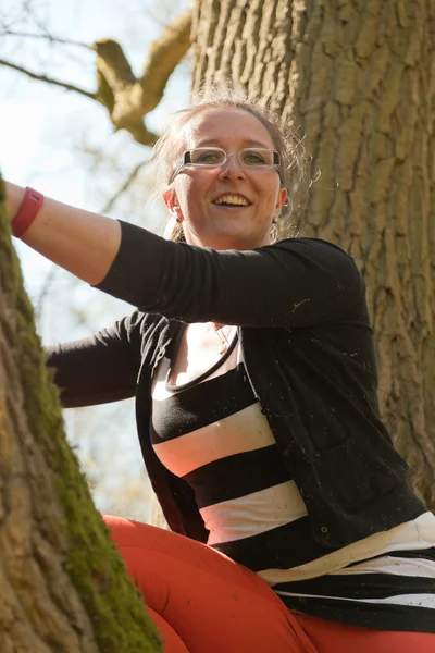 Single glücklich junge Frau hat Spaß im Baum. — Stockfoto